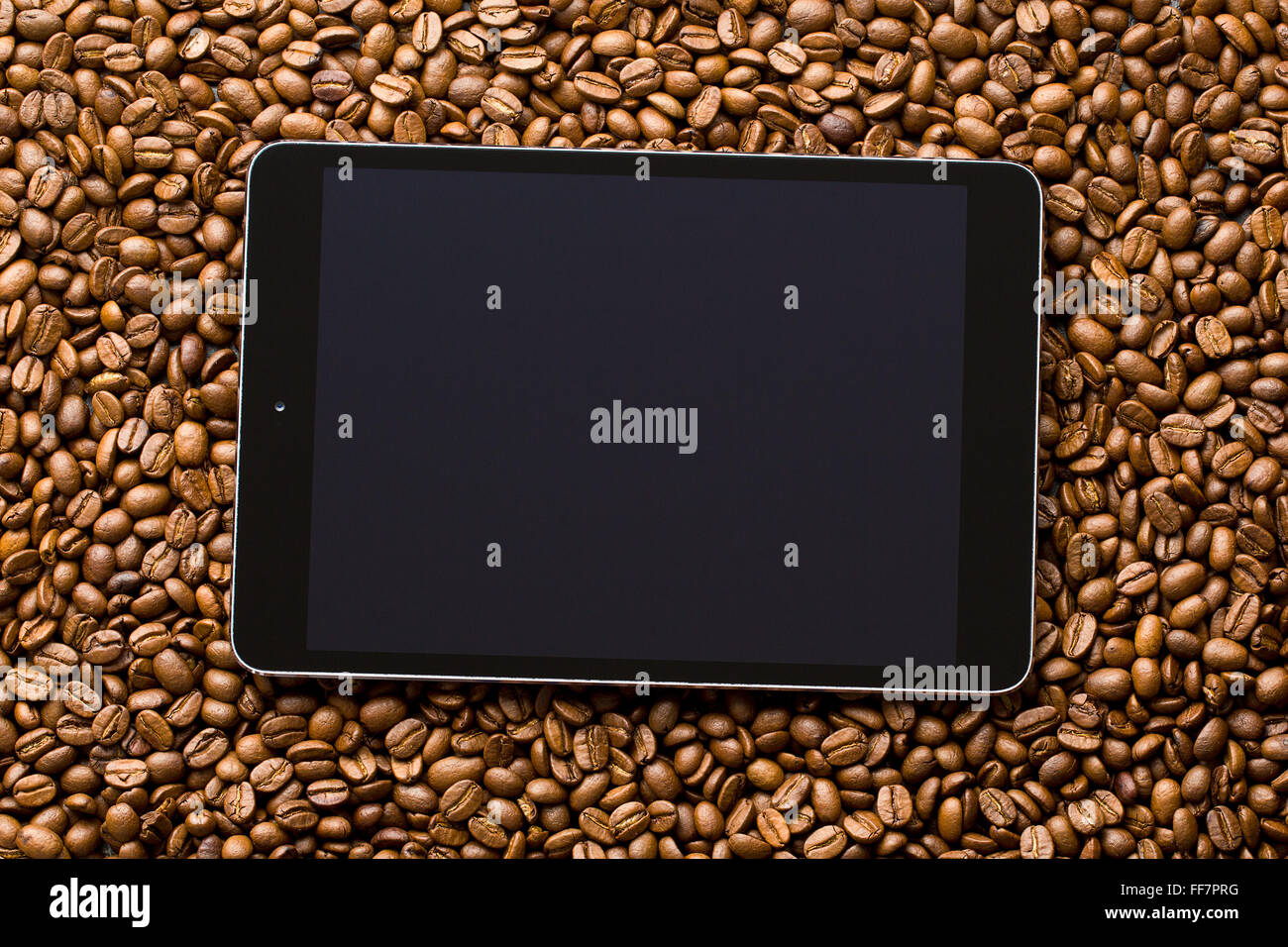 L'ordinateur tablette sur les grains de café Banque D'Images