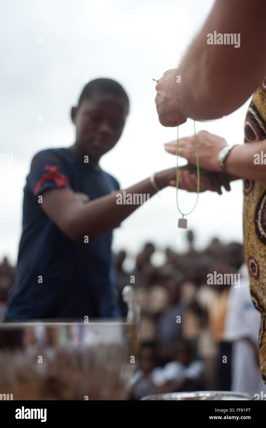 Mali, Afrique - White lady récompense un garçon noir pour un match de football près de Bamako Banque D'Images