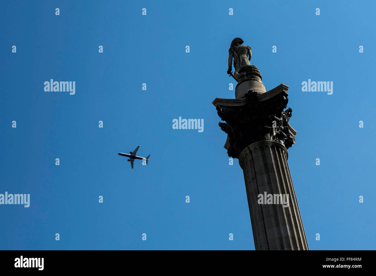 Un avion vole au-dessus de la colonne des frais généraux Nelsons, Trafalgar Square, Londres, Royaume-Uni. Banque D'Images