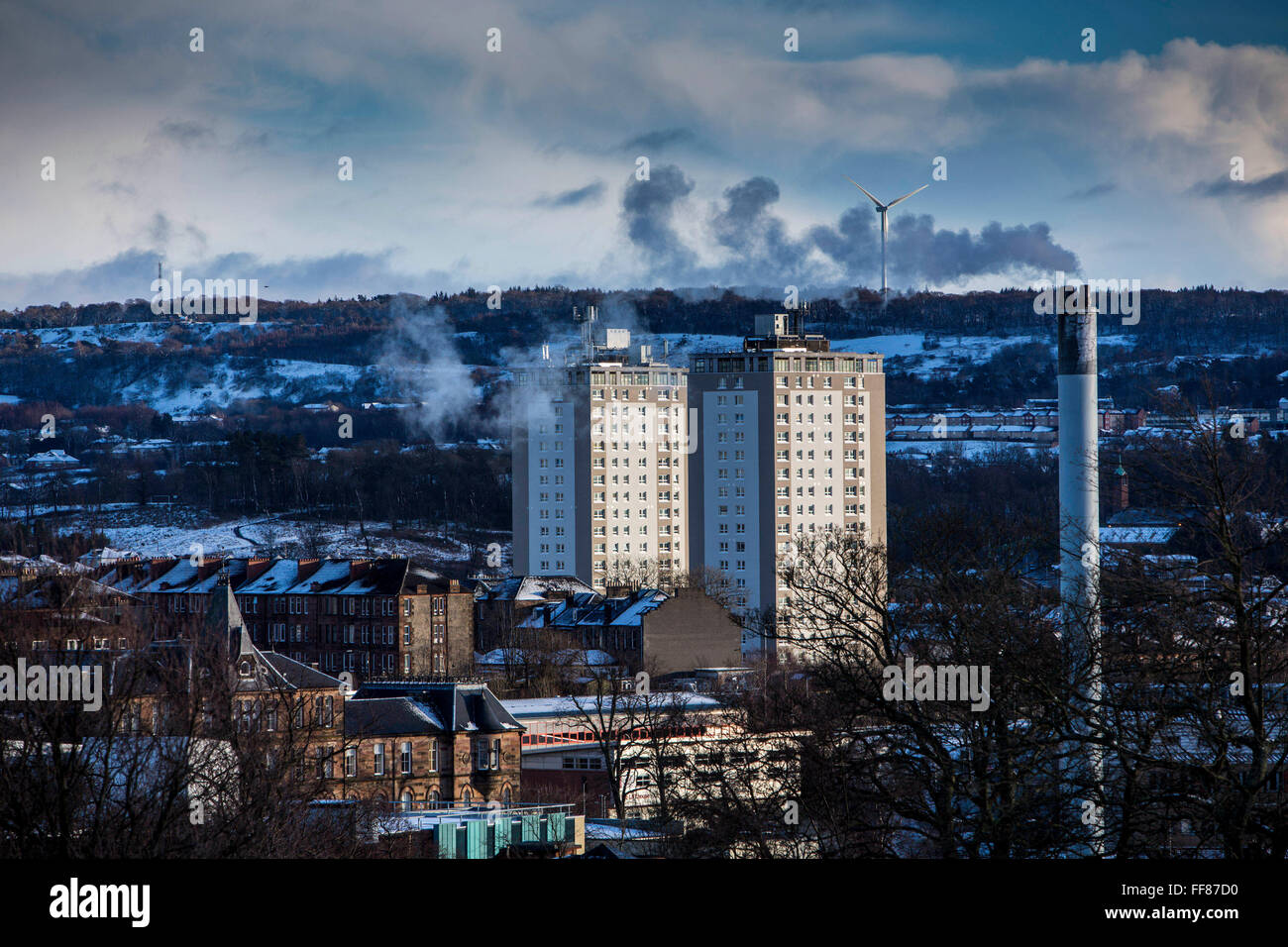 Deux blocs d'appartements, d'une cheminée et d'un tabagisme éolienne sur Glasgow South Side prises de Queens Park, Glasgow. Banque D'Images