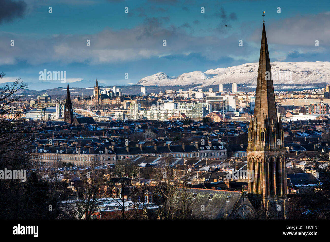 Le clocher en grès de Queen's Park Baptist Church prises de Queens Park. Le parc est connu pour sa vue sur le côté sud de Glasgow, avec un couvert de neige Campsie Fells en arrière-plan. Banque D'Images