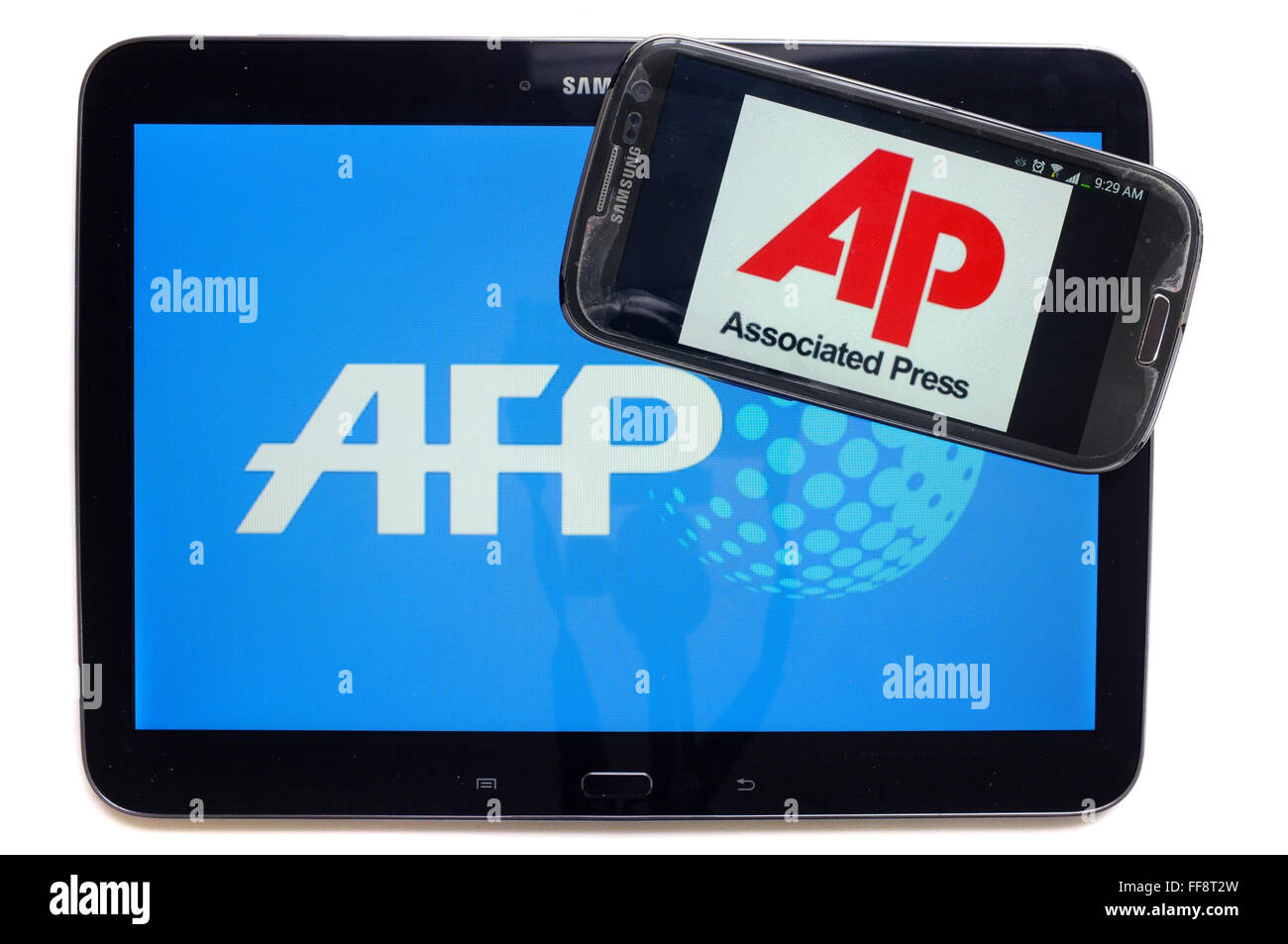 Les agences de presse AFP et AP sur les écrans d'une tablette et un smartphone photographié sur un fond blanc. Banque D'Images