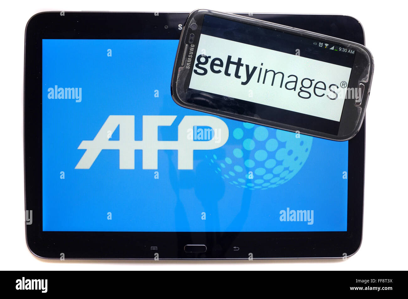 Les agences de presse AFP et getty images sur l'écran d'une tablette et un smartphone photographié sur un fond blanc. Banque D'Images