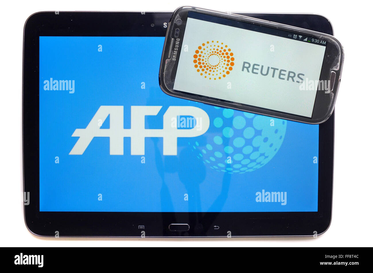 Les agences de presse AFP et Reuters sur les écrans d'une tablette et un smartphone photographié sur un fond blanc. Banque D'Images