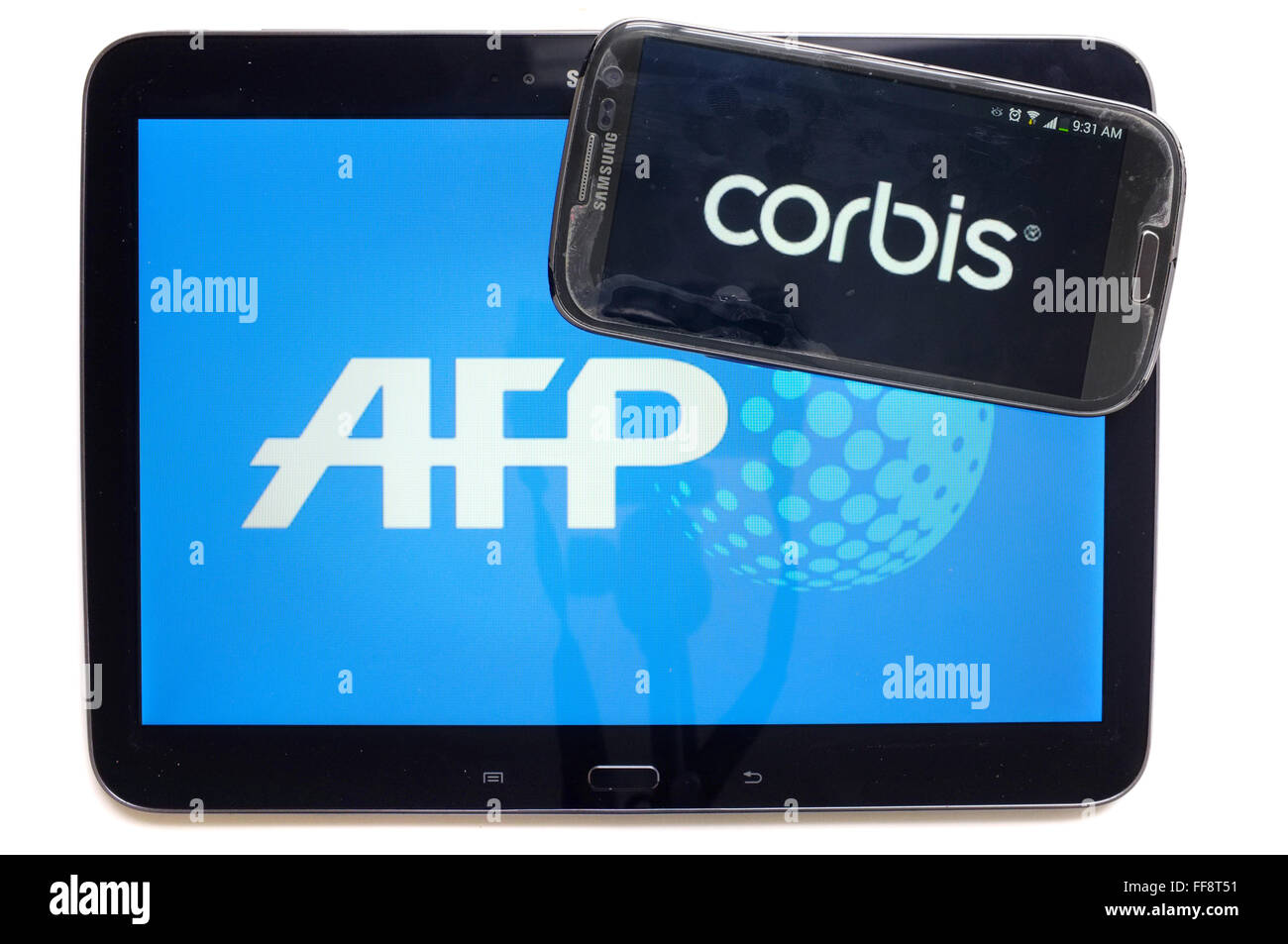 Les agences de presse AFP et Corbis sur les écrans d'une tablette et un smartphone photographié sur un fond blanc. Banque D'Images