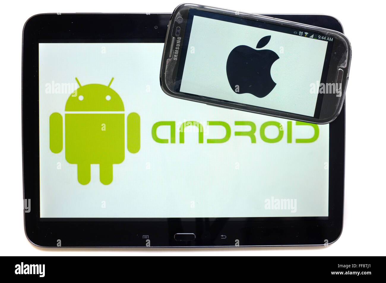 Le logo Apple sur un écran de smartphone sur le dessus d'une tablette affichant le logo Android photographié sur un fond blanc. Banque D'Images