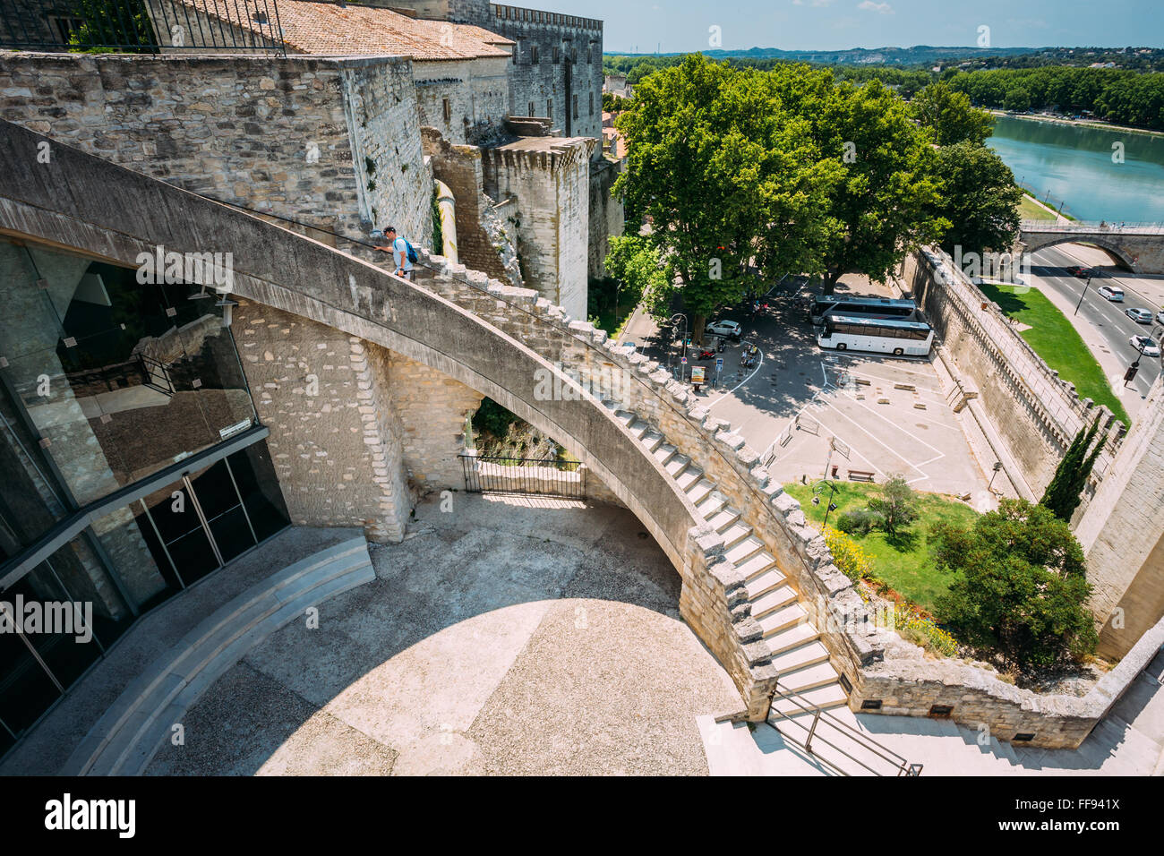 L'homme monte les escaliers aux murs de la forteresse près du palais des Papes à Avignon, France. Banque D'Images