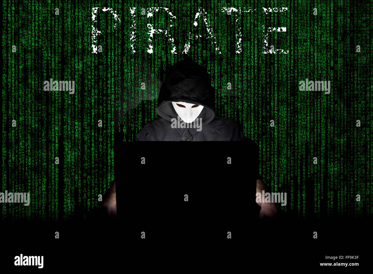 Un homme masqué à un ordinateur portable symbolisant les dangers de l'Internet. Banque D'Images