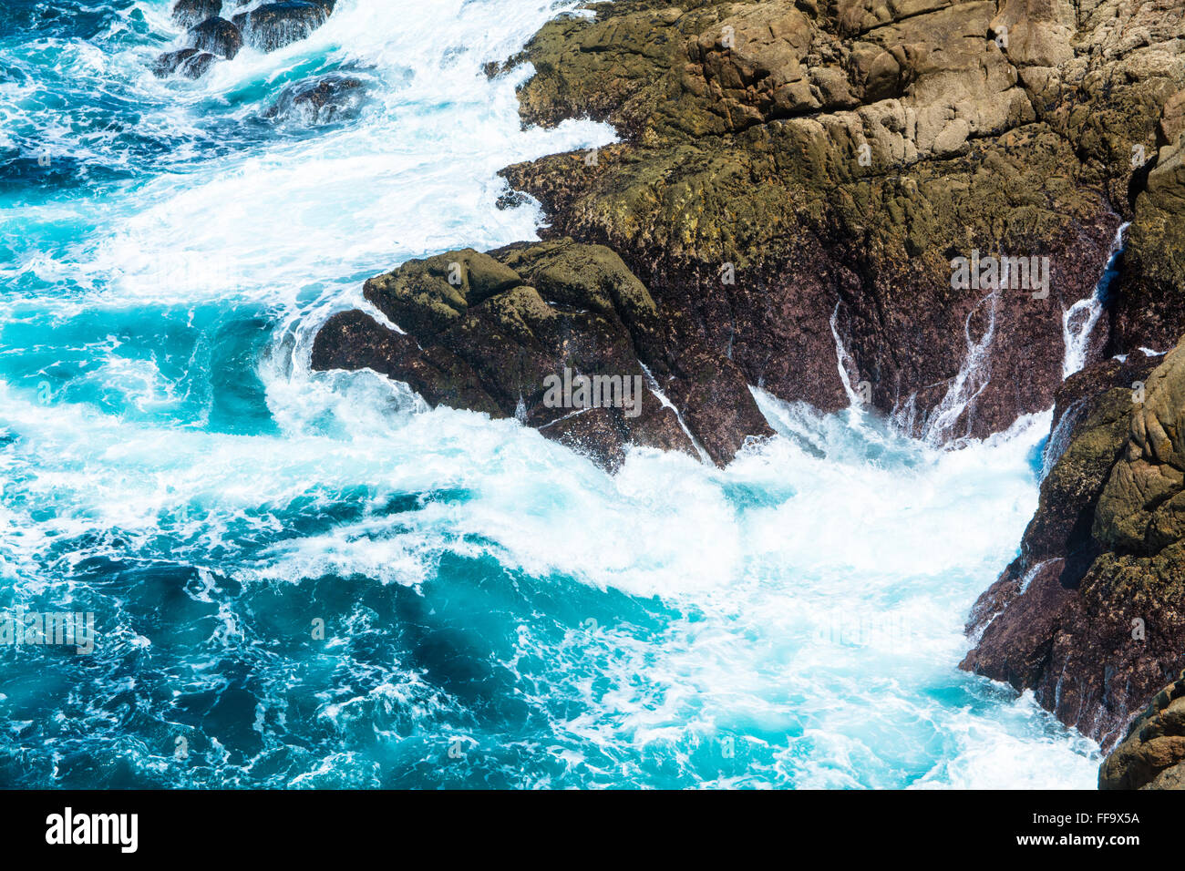 Rock Formation en bleu océan avec des vagues et de l'eau éclaboussant Foam Banque D'Images