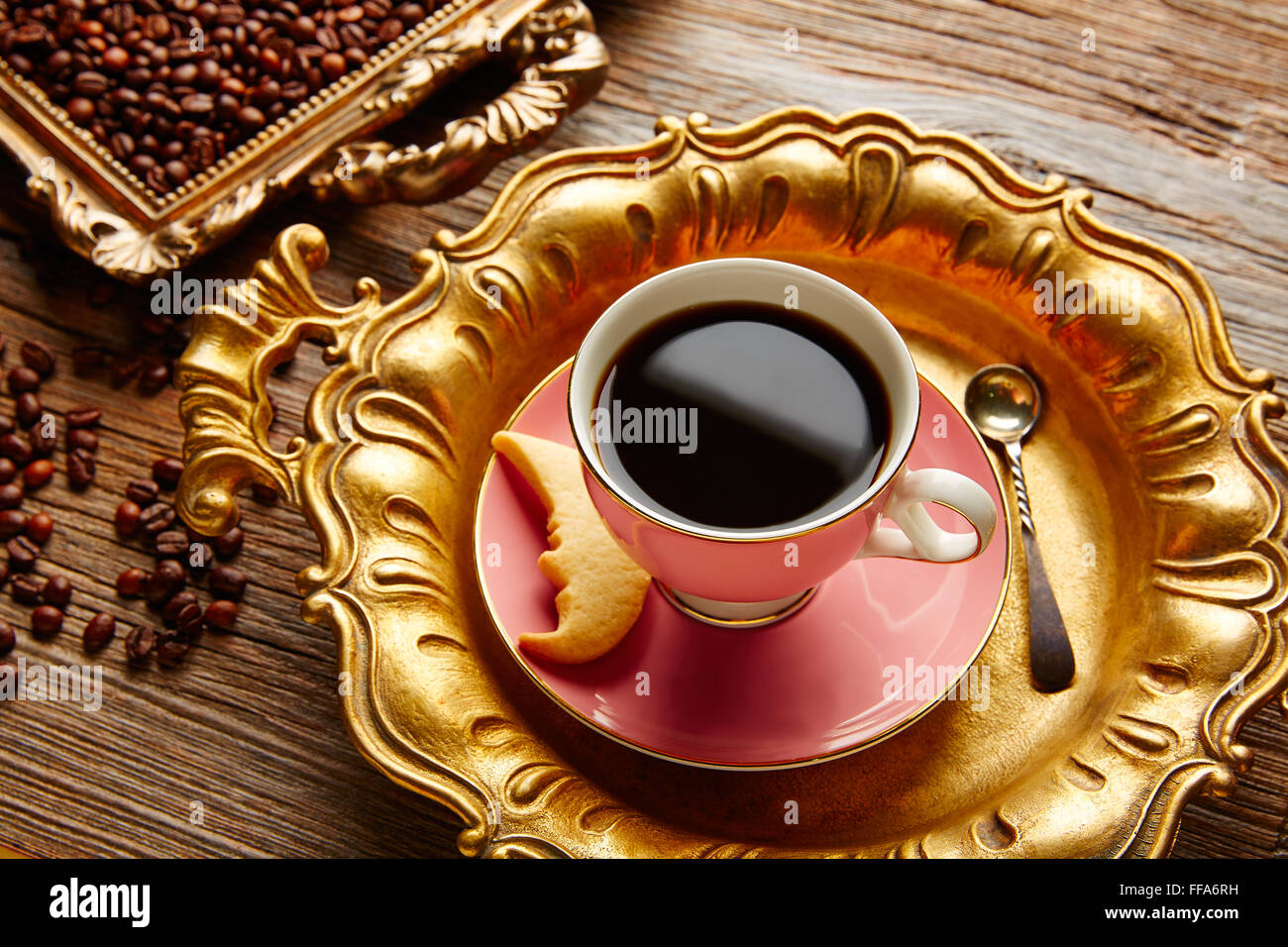 Tasse à café et haricots sur vintage golden plateau dans l'ancienne table en bois Banque D'Images