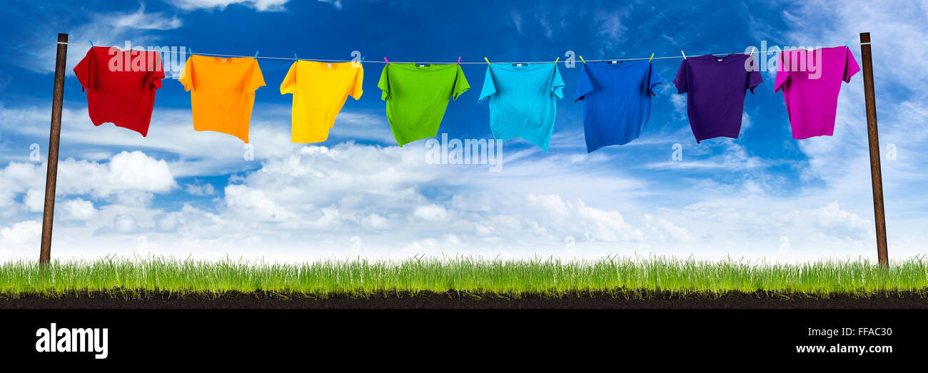 Tshirts colorés sur la ligne de lavage sur pré vert Banque D'Images