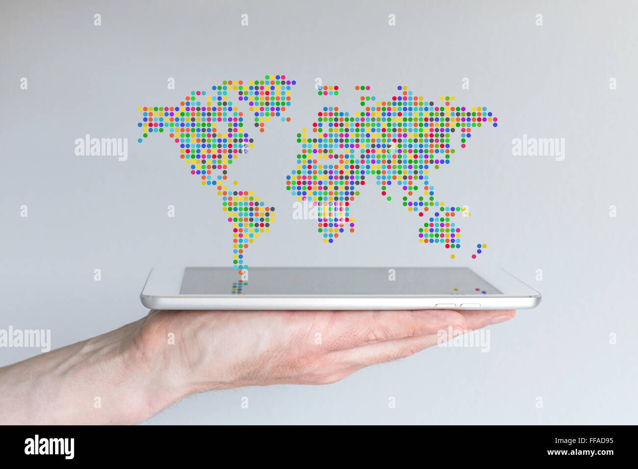 Carte du monde flottant au-dessus d'un téléphone intelligent ou une tablette moderne. Main tenant appareil mobile en face de fond gris. Banque D'Images