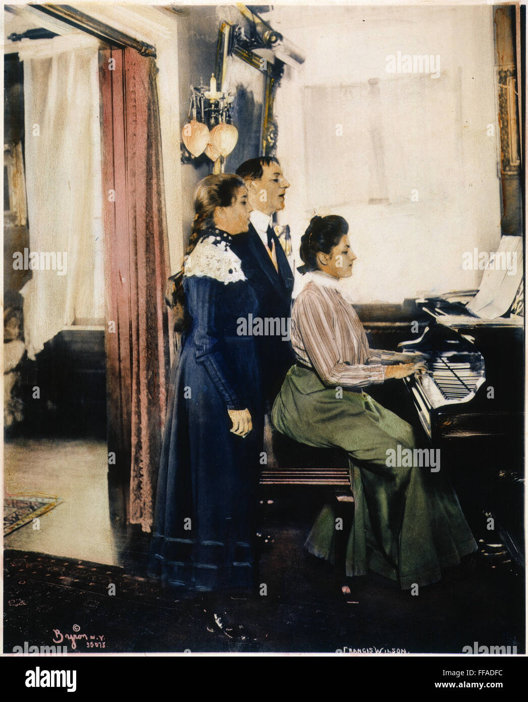 La MUSIQUE À LA MAISON, 1900. /NAn American family faire de la musique dans le salon : l'huile à une photographie, c1900. Banque D'Images