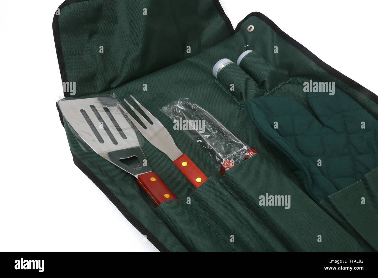 Des ustensiles de barbecue Set- spatule, fourchette, pince, mitaine de four et salières et poivrières tous enveloppés dans Apron Banque D'Images