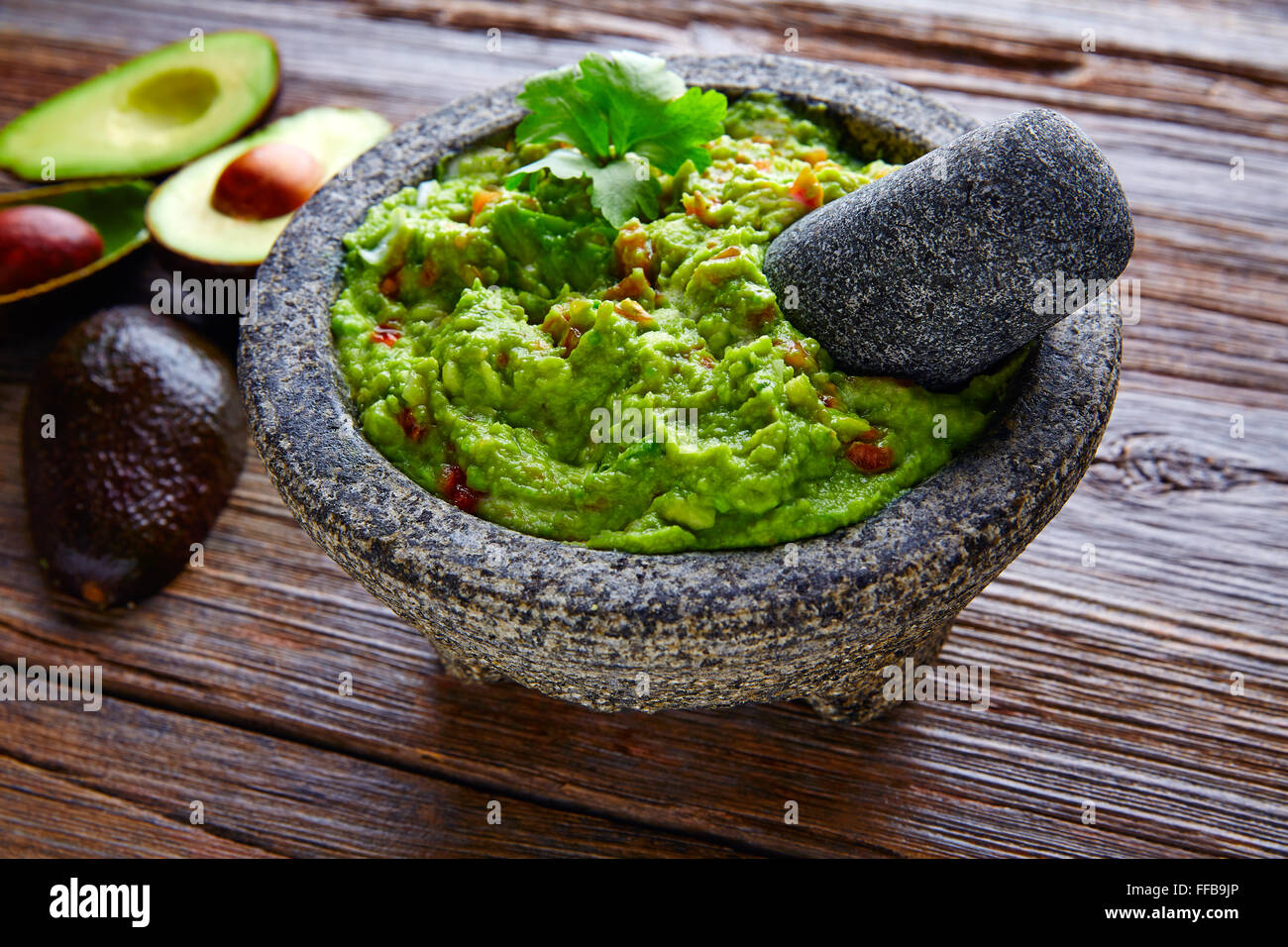 Avocado Guacamole mexicain sur molcajete procédure traditionnelle Banque D'Images