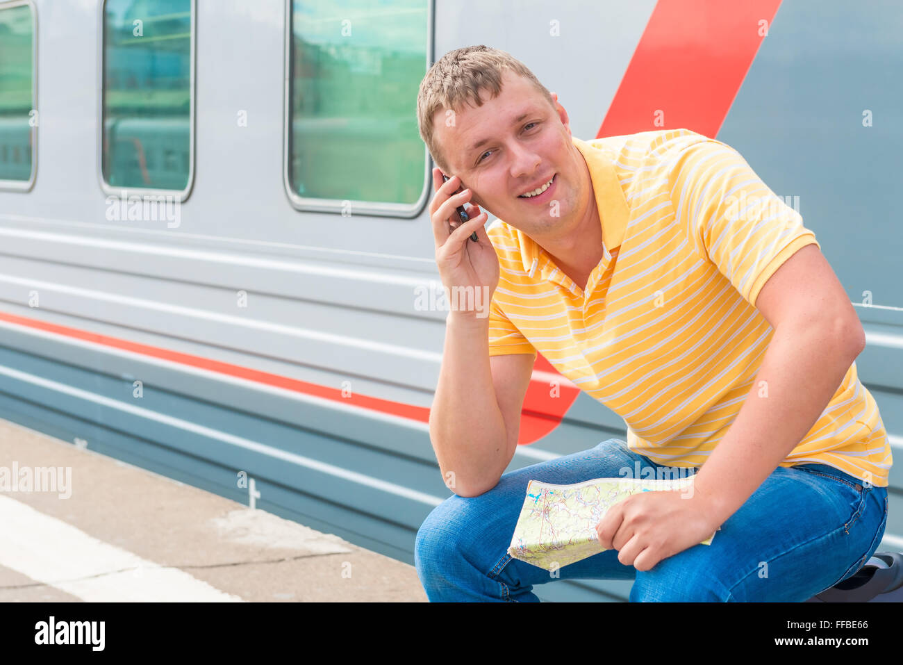 Homme heureux avec le téléphone en prévision d'un voyage dans le train Banque D'Images