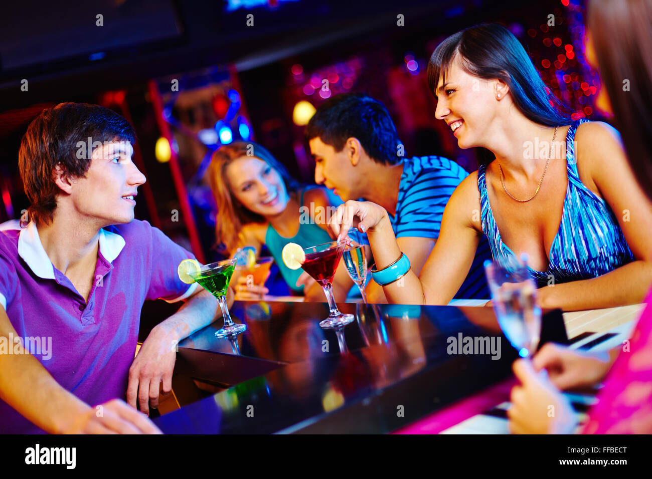 Young man and woman talking at nightclub Banque D'Images