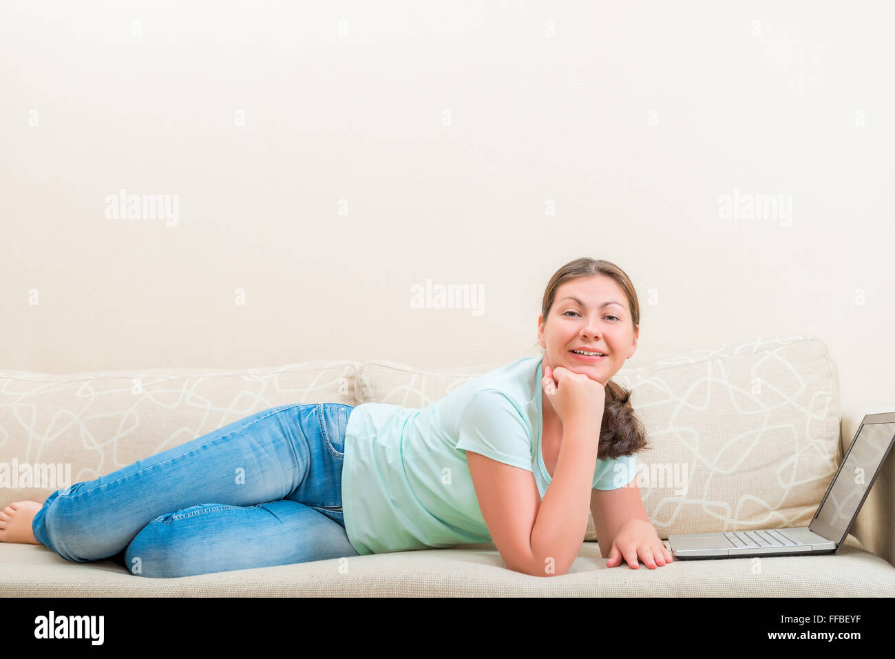 Belle jeune fille insouciante allongé sur le canapé dans le salon Banque D'Images