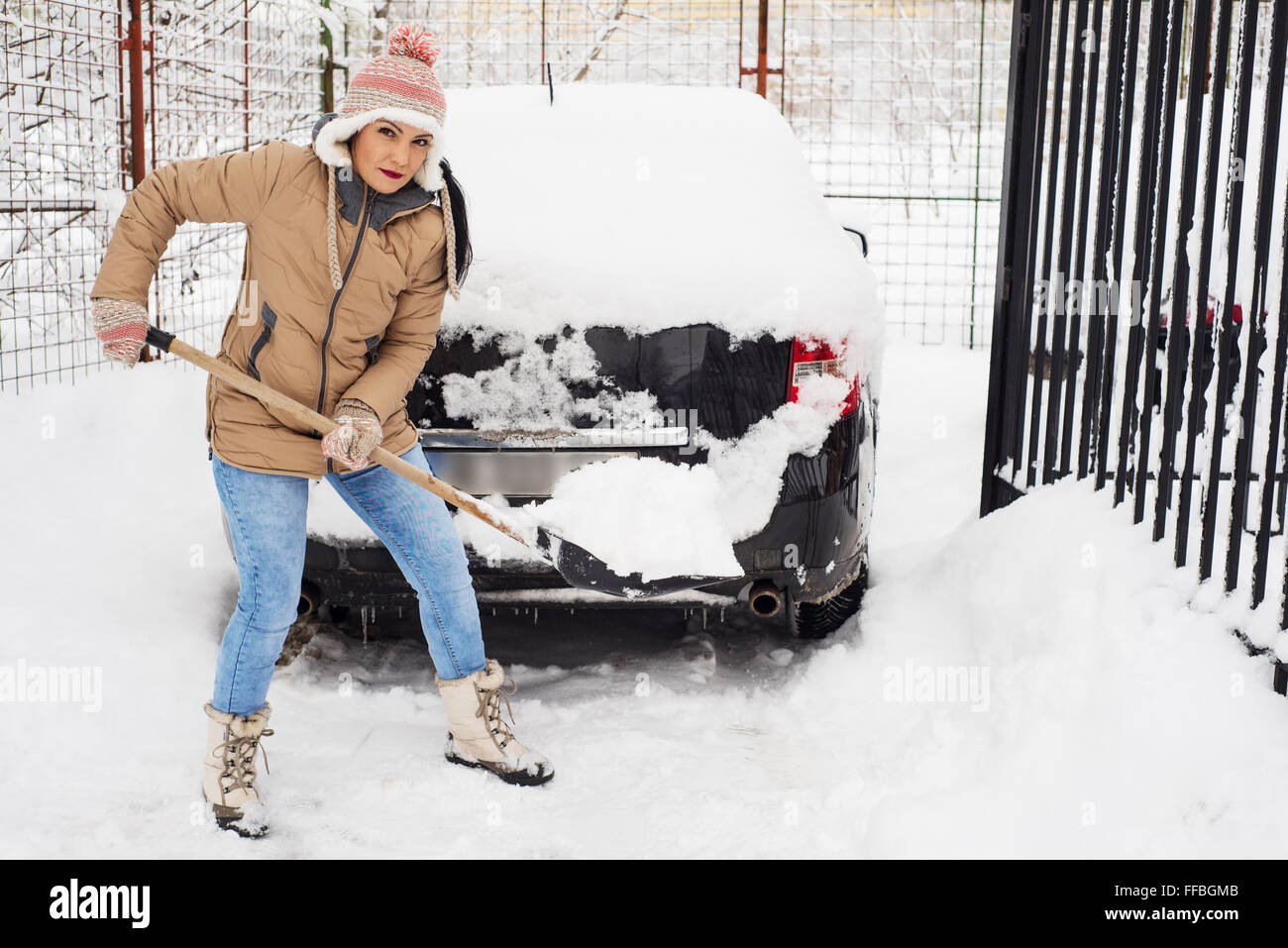 Woman holding pelle à neige et neige par chemin de nettoyage Banque D'Images