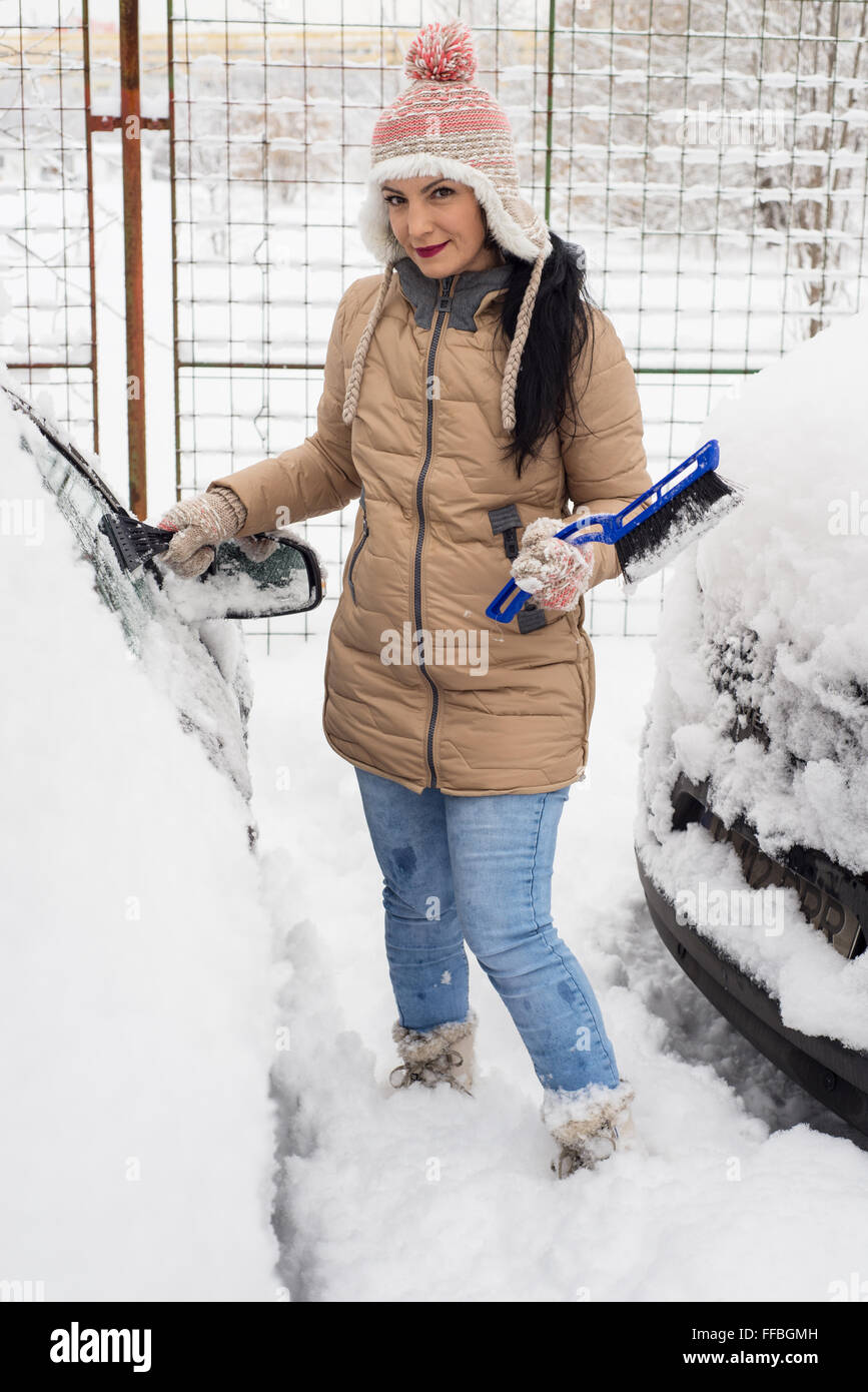 Cheerful woman snow de voiture en journée froide Banque D'Images