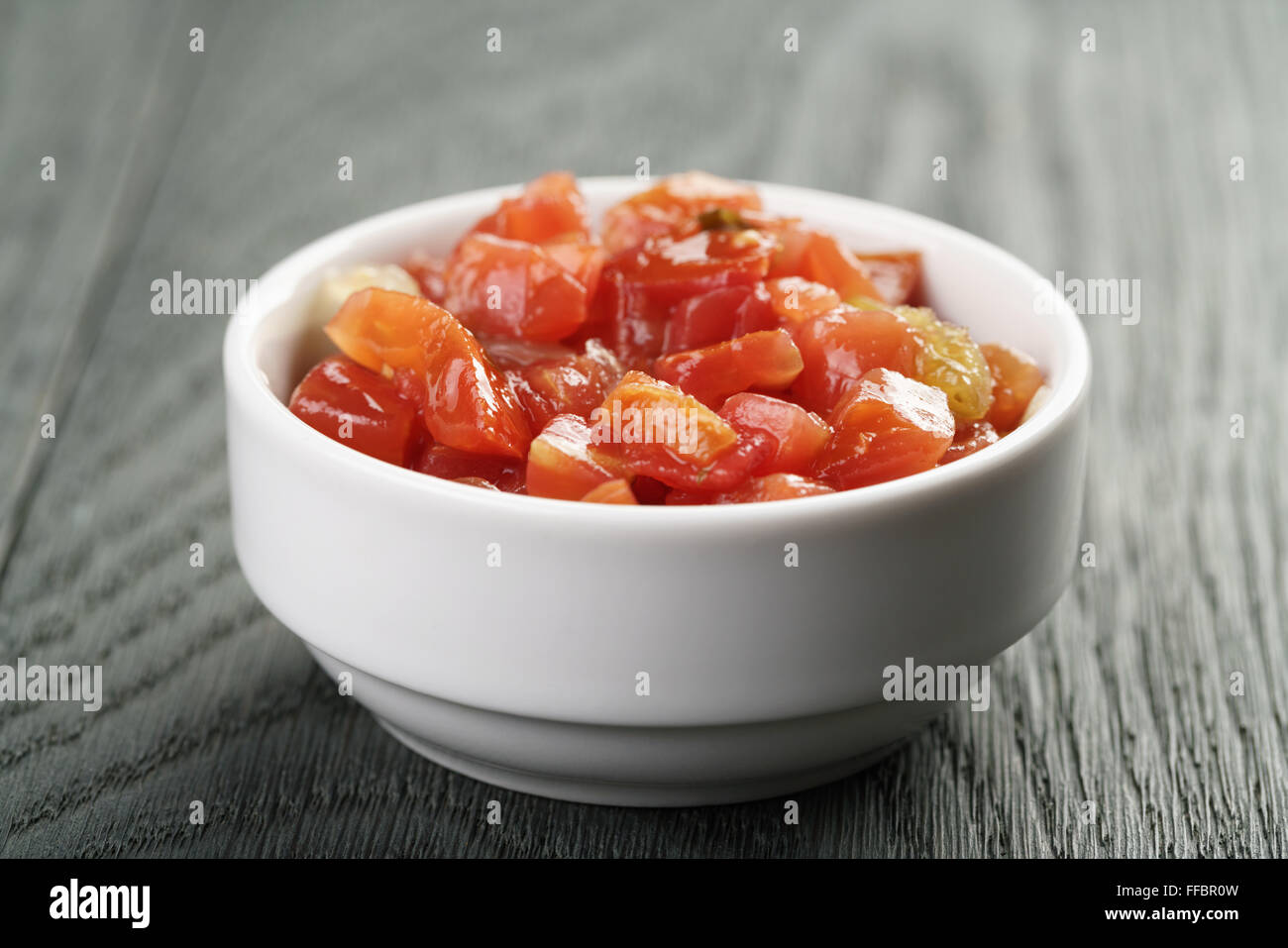 Plongeon dans la salsa en conserve sur table en bois bol Banque D'Images