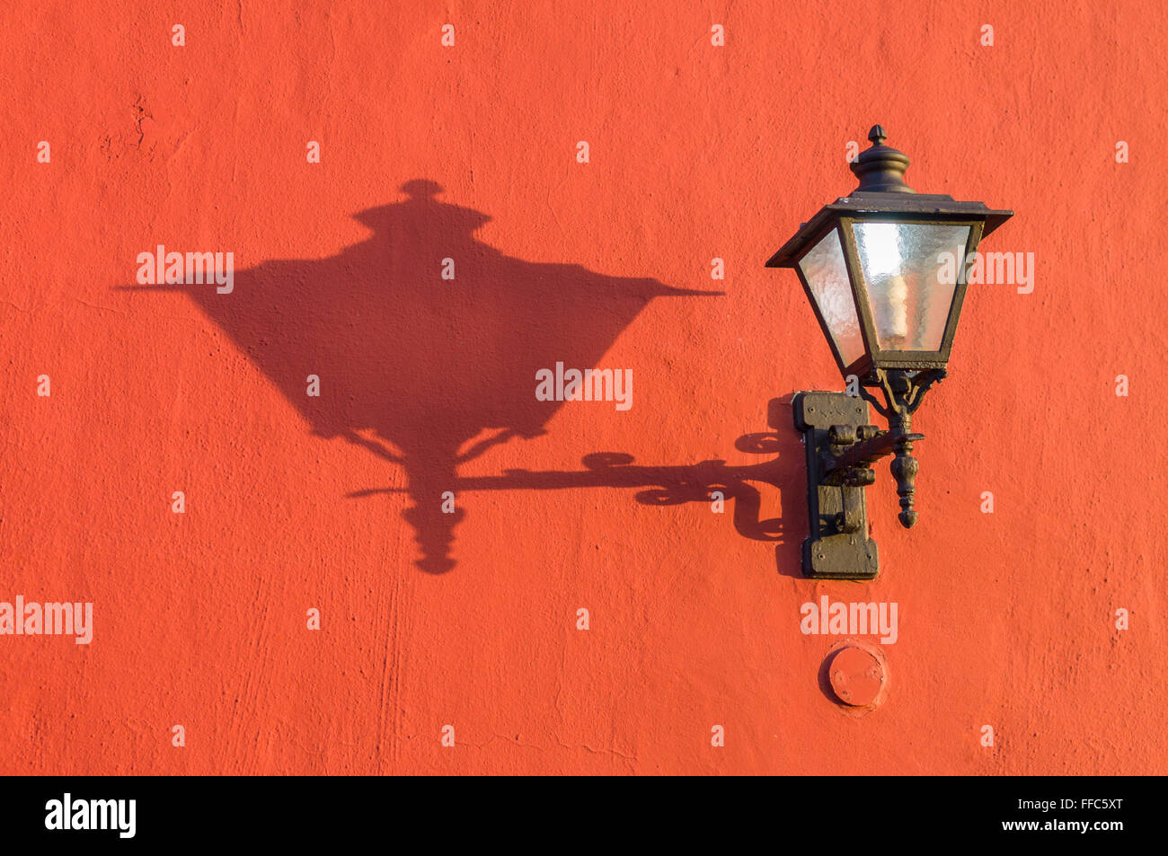 Vieille rue lanterne sur le mur de l'ombre à la lumière au coucher du soleil Banque D'Images