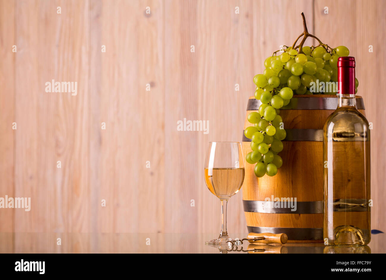 Bouteille de vin en verre avec un baril et le raisin et fond clair Banque D'Images