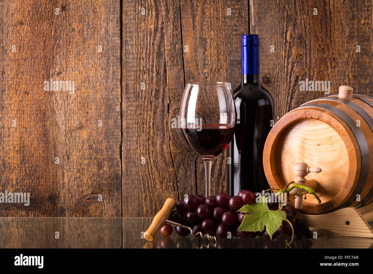 Verre de vin rouge bouteille avec fond de bois et de raisins du fourreau Banque D'Images
