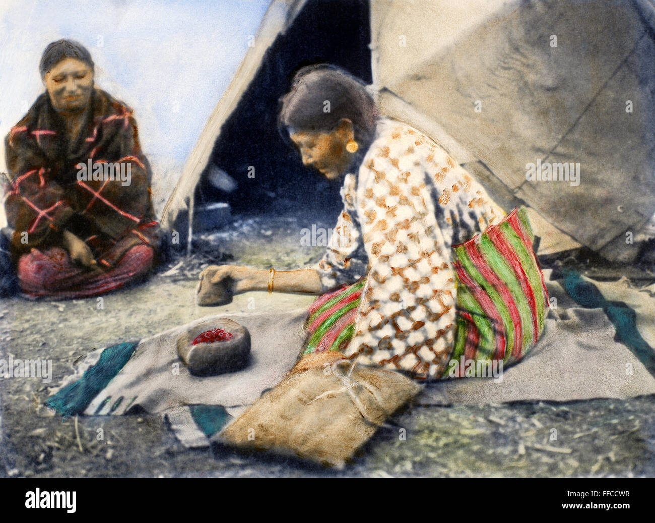 CHEYENNE WOMAN, 1890. /Nà une pierre mortier et pilon, une femme Cheyenne prépare les cerises sauvages, de puits et de tous, pour la fabrication du pemmican. Huile à une photographie, 1890. Banque D'Images