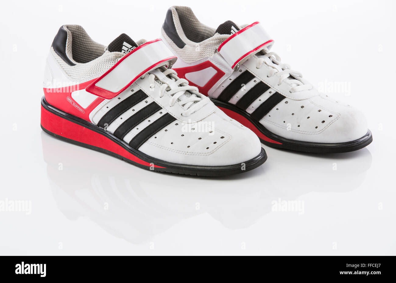 Chaussures haltérophilie Adidas sur un fond blanc avec un reflet. Banque D'Images