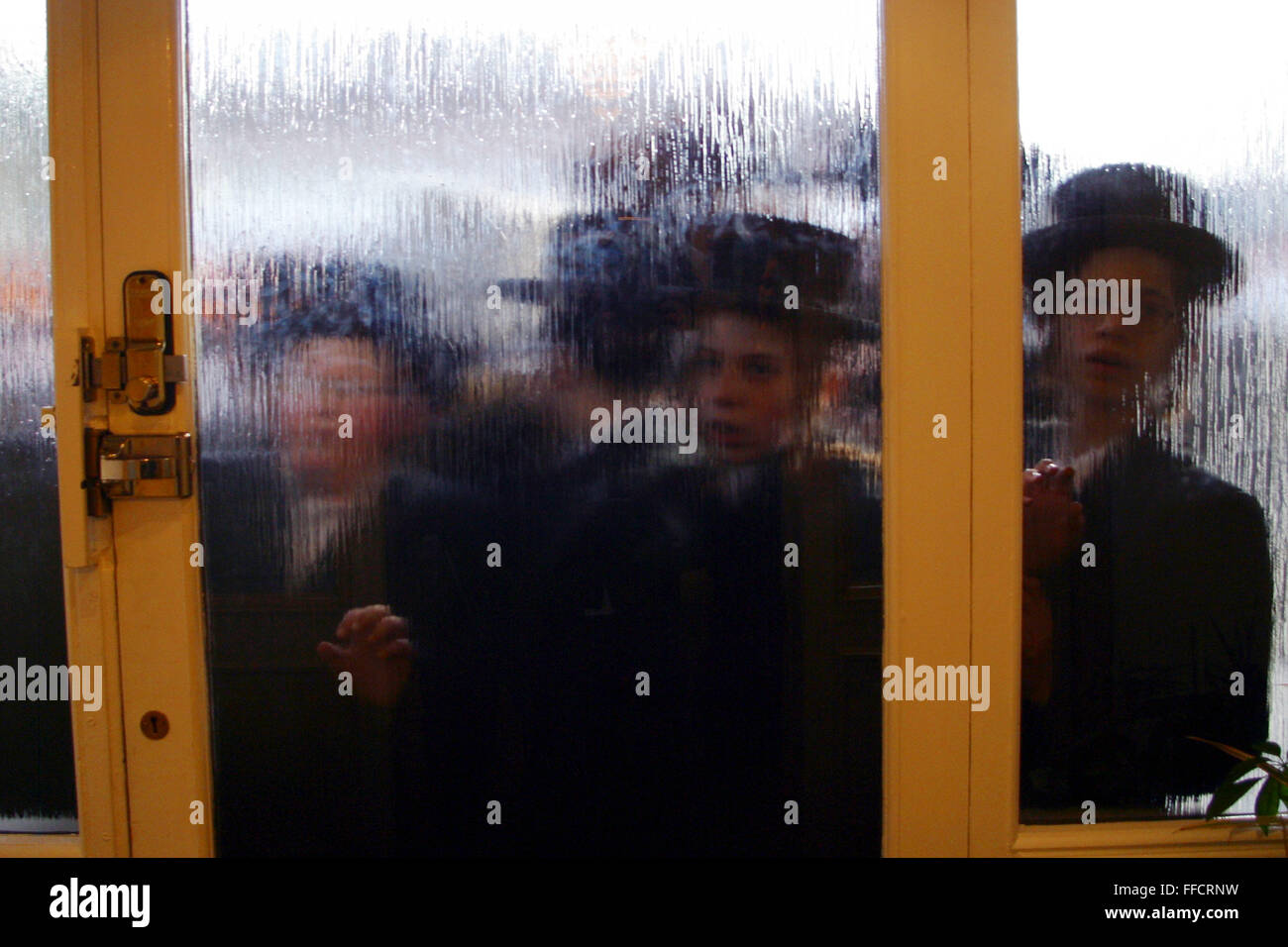 Un groupe de garçons juifs orthodoxes en robe de la collecte pour la charité essayer et visiter un homme riche de la région ; certaines maisons sont si populaires qu'ils doivent attendre pour obtenir dans et ils ont des videurs sur la porte. Pourim est l'une des plus divertissantes fêtes juives. Elle commémore le moment où le peuple juif vivant en Perse a été sauvé de l'extermination d'un massacre par Haman. Grâce au courage d'une jeune femme juive Esther. Il est de coutume d'organiser des célébrations de Carnaval sur Pourim, et que des groupes d'hommes pour faire le tour sur l'arrière de camions et en bus découvert visiter les riches Banque D'Images