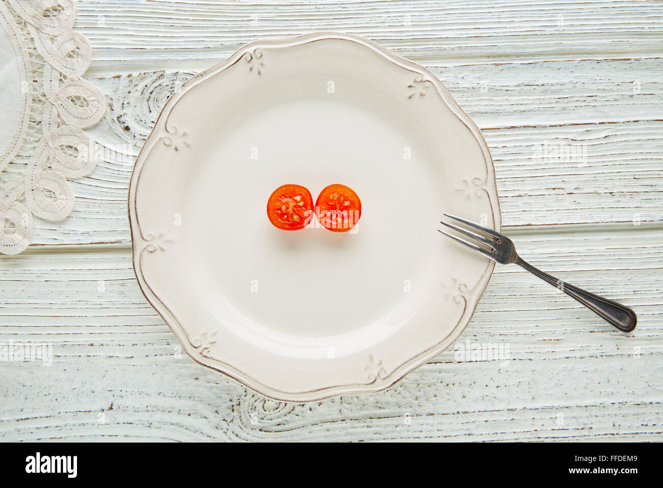 Tomate cerise coupées en plaque blanche minimaliste de matières la nourriture végétarienne Banque D'Images