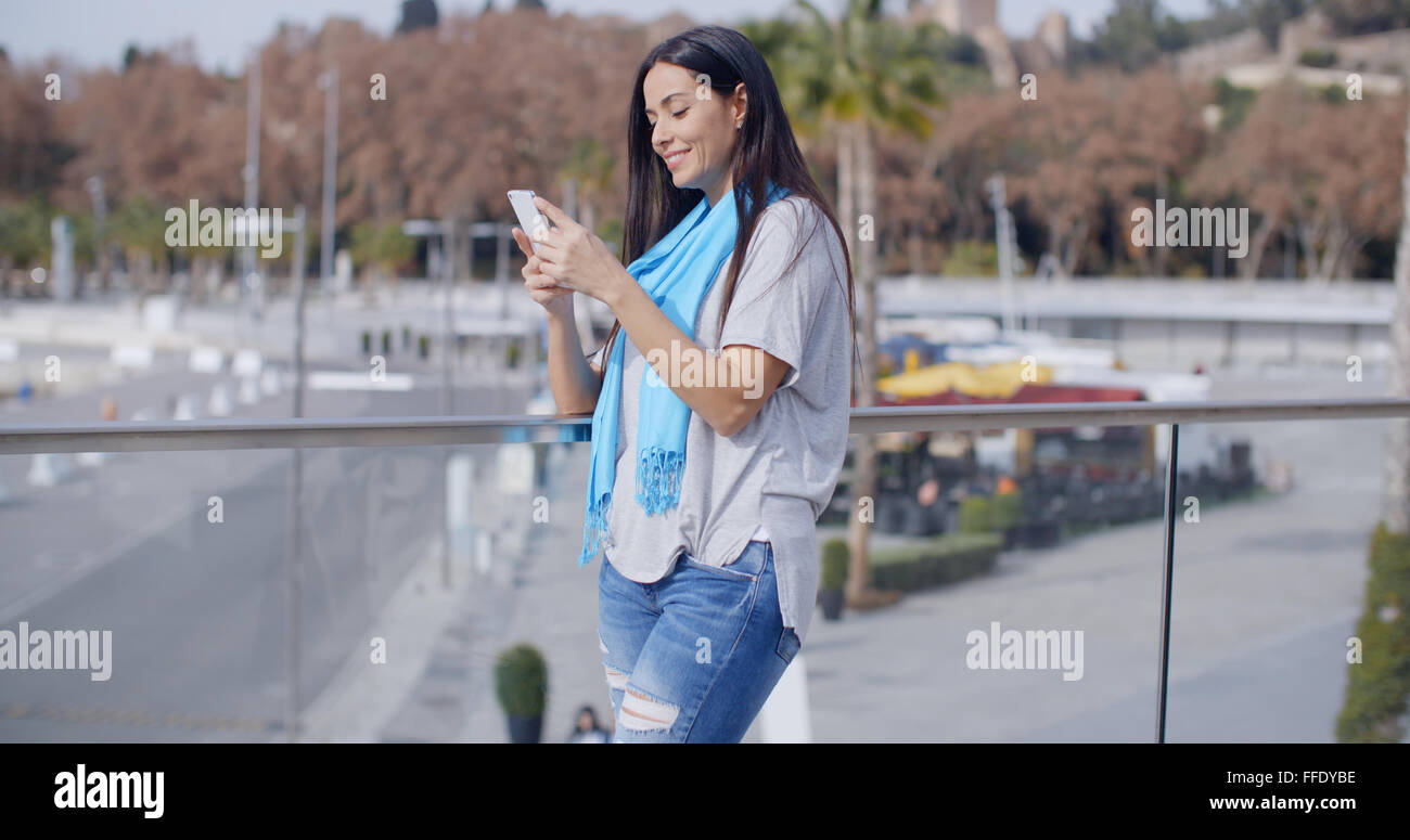 Femme sourire à l'aide de téléphone sur viaduc Banque D'Images