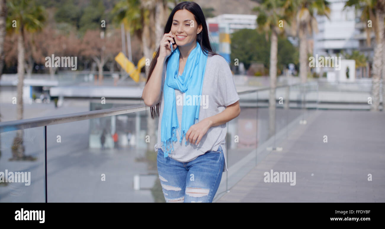 Femme marchant le long d'une promenade avec mobile Banque D'Images