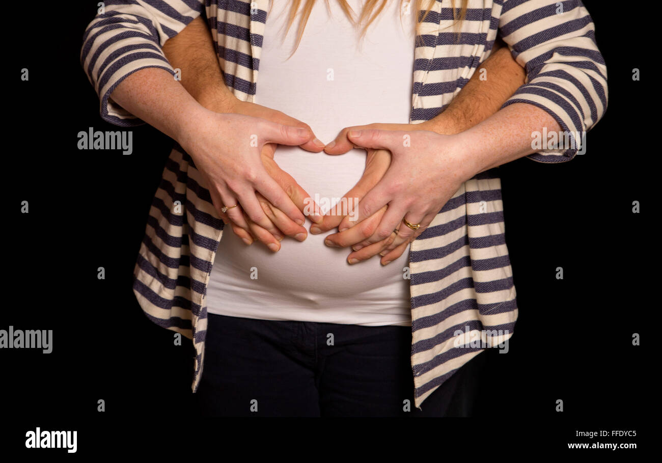 Homme et femmes holding baby bump Banque D'Images