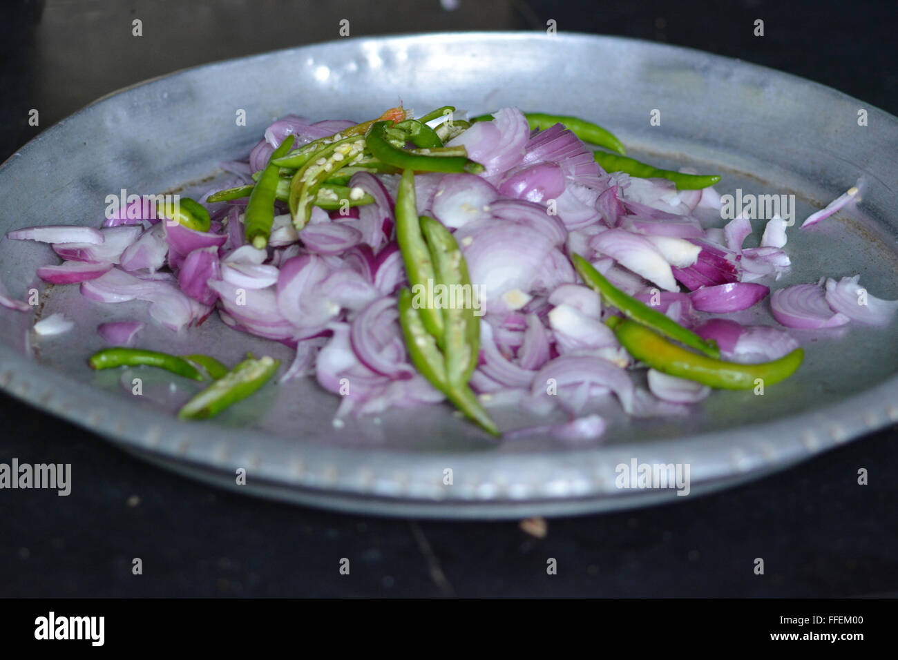 Mumbai, Inde - le 28 octobre 2015 - coupe femme piment et oignons sur un tabouret dans la coupe traditionnelle cuisine indienne Banque D'Images