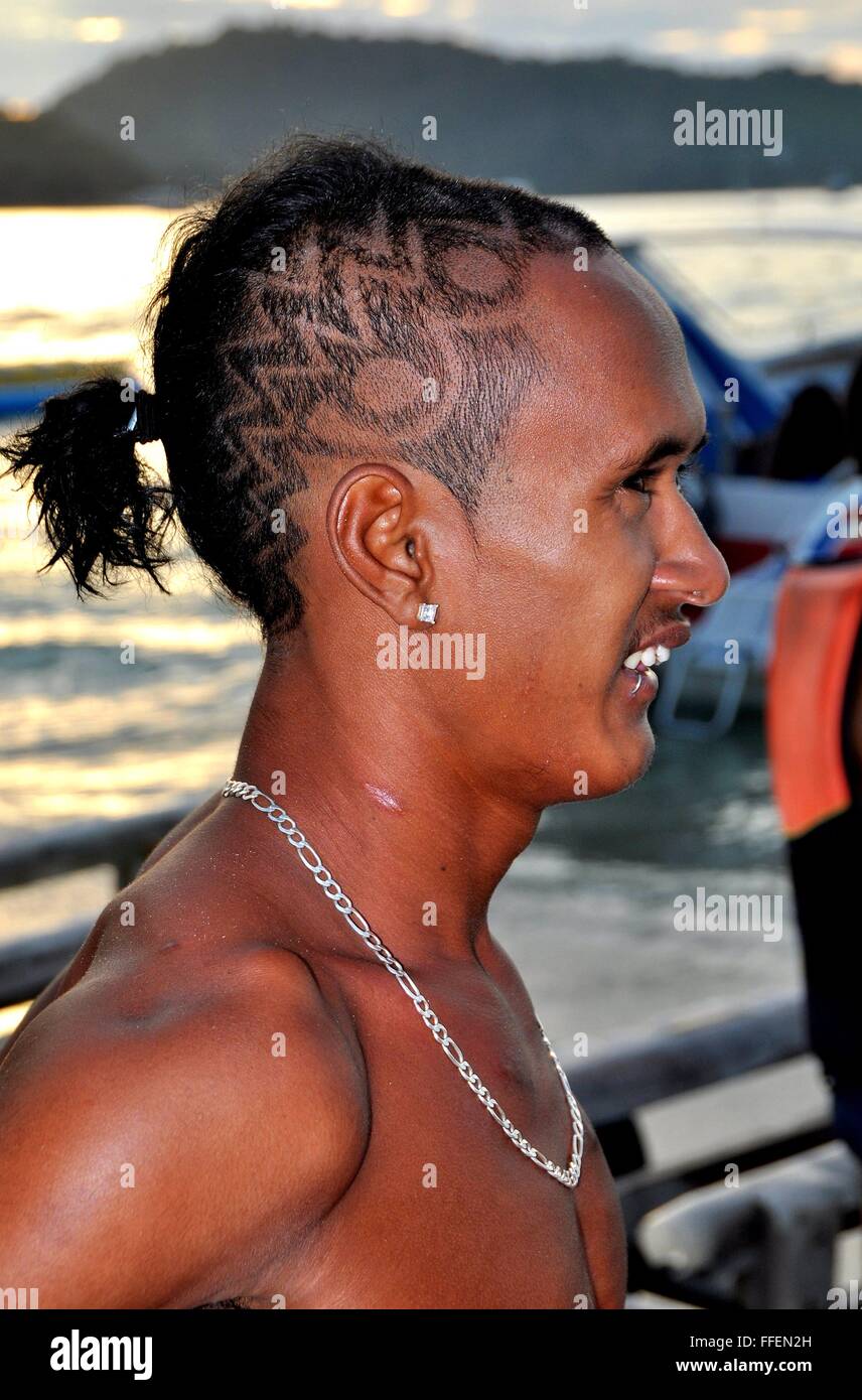 Phuket, Thailande : Thai beach boy travailleur avec coupe très tendance avec des dessins géométriques Banque D'Images