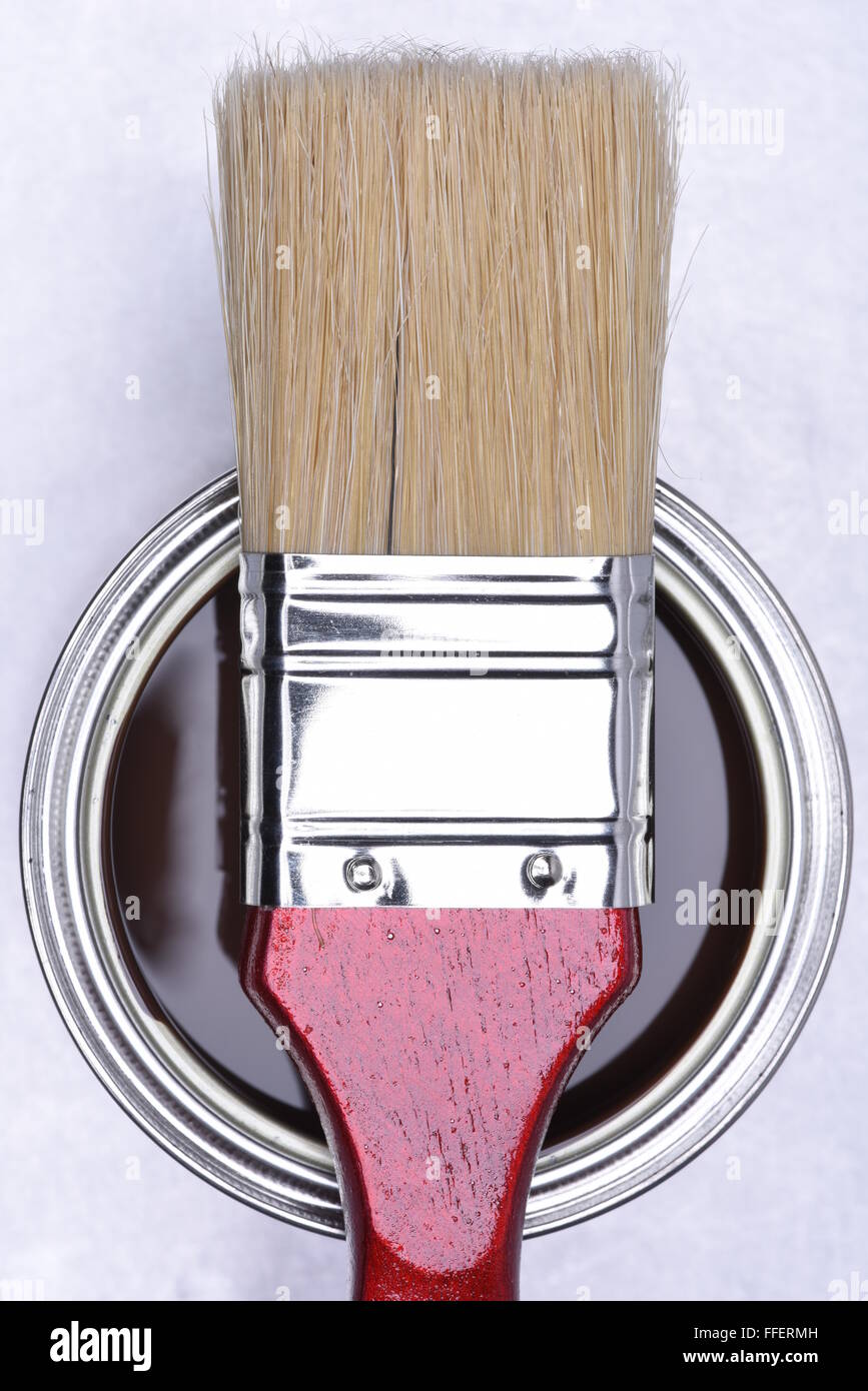 Vue de dessus de la peinture marron pouvez avec pinceau rouge sur fond gris metal Banque D'Images