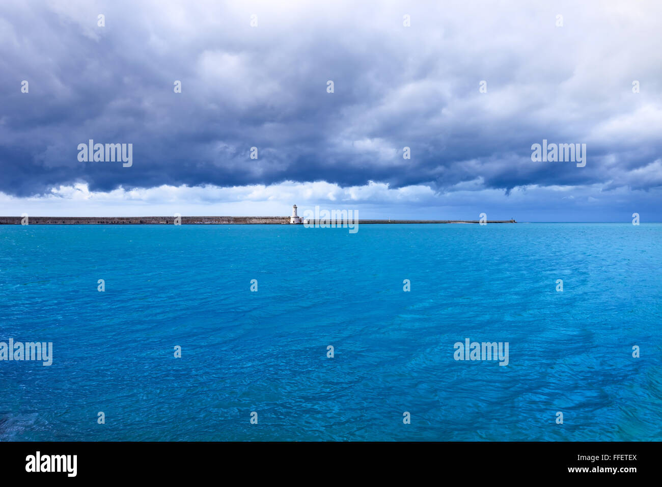Port de Livourne phare, brise-lames et de l'eau sous le mauvais temps nuageux ciel. La Toscane, Italie, Europe. Photos à longue exposition. Banque D'Images
