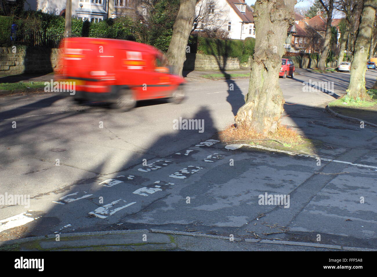 Un camion de livraison postale durs par un arbre qui grandit au milieu d'un carrefour dans une banlieue verdoyante de la ville de Sheffield, Royaume-Uni Banque D'Images