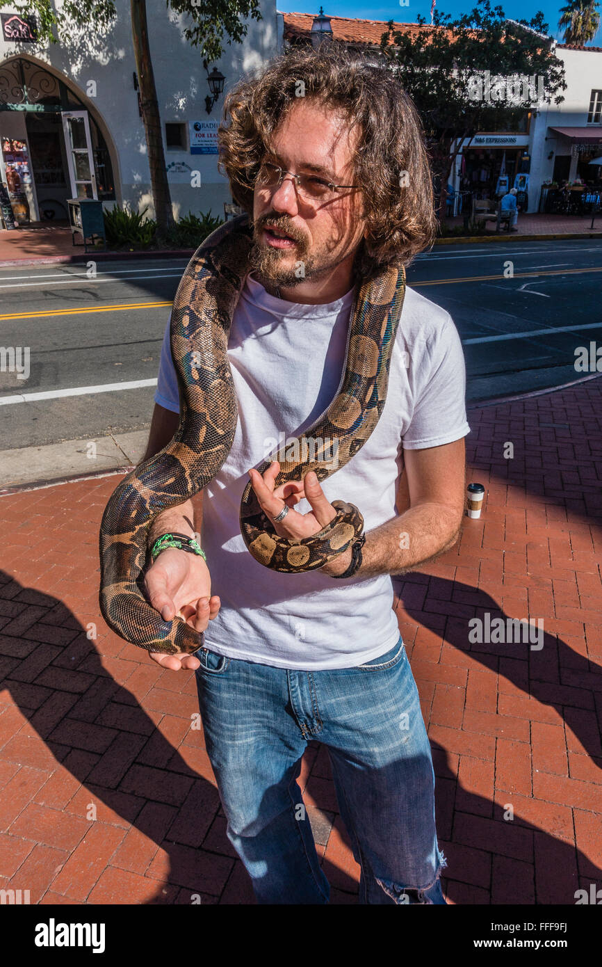 Propriétaire d'un serpent boa constrictor colombien ses rideaux autour de son cou alors qu'il montre le serpent pour piétons à collecter de l'argent. Banque D'Images