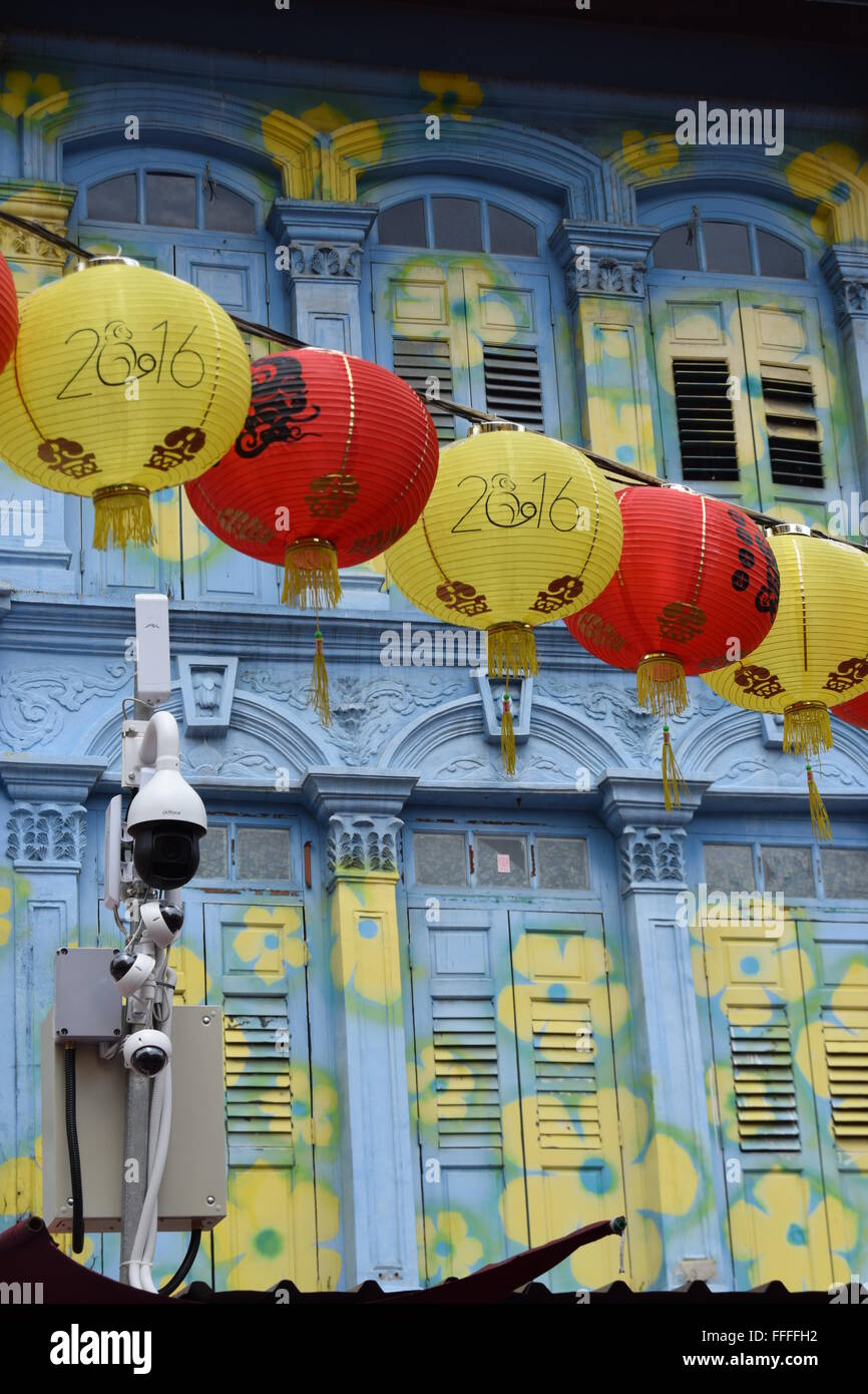 Singapour : Shop house dans le quartier chinois pendant le Nouvel An chinois avec façade bleue et jaune fleurs et une chaîne de lanternes chinoises Banque D'Images