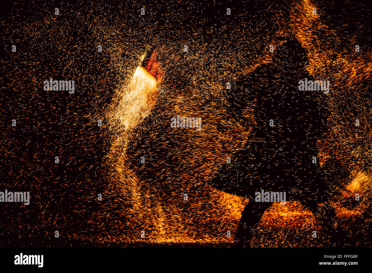 Spectacle de feu la nuit. Silhouette noire de l'homme contre la toile de fond de fiery étincelles Banque D'Images