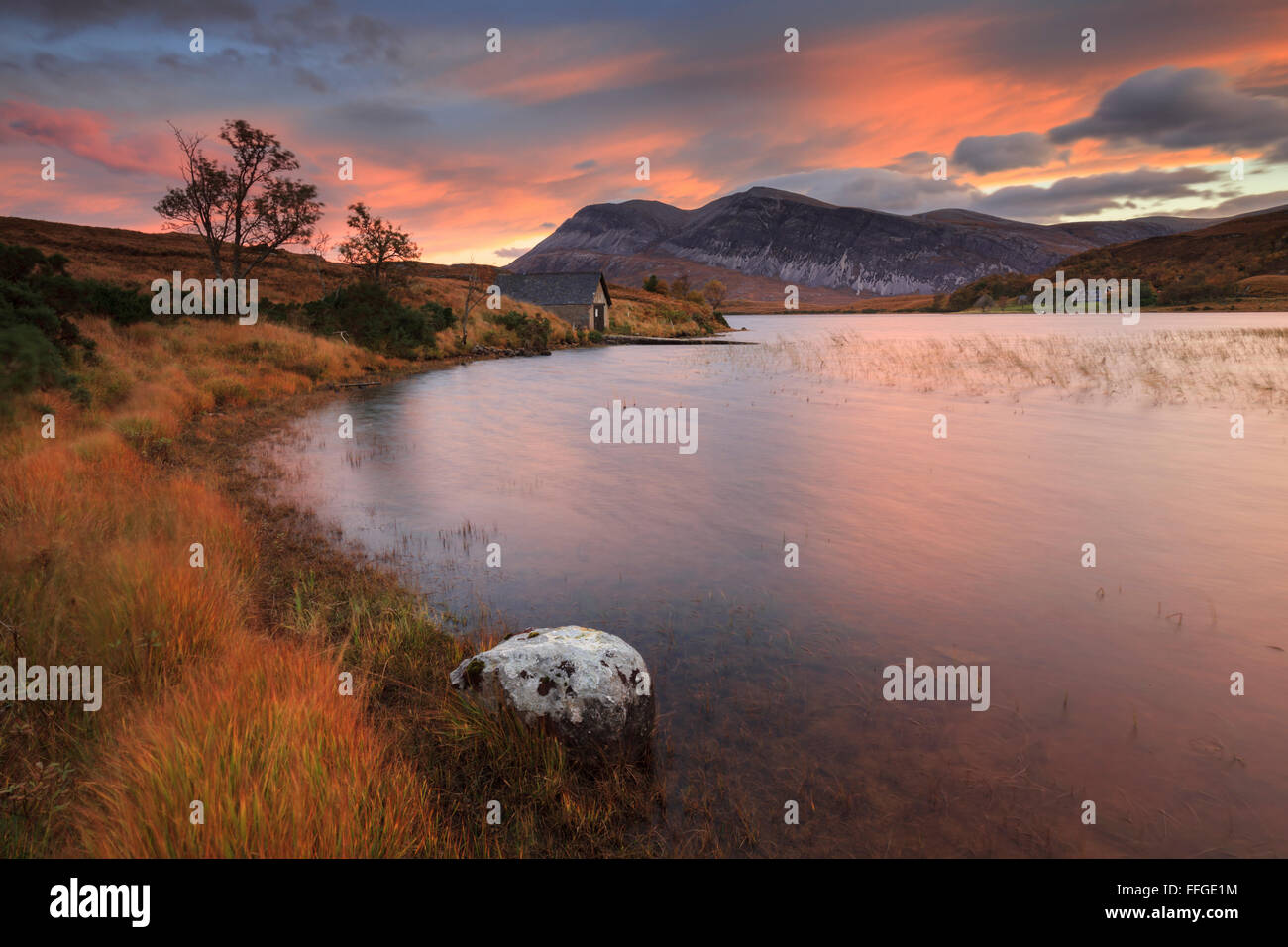 La remise à bateaux à l'extrémité sud du Loch Stack, dans le nord-ouest des Highlands d'Écosse, capturés au lever du soleil à la fin d'octobre. Banque D'Images