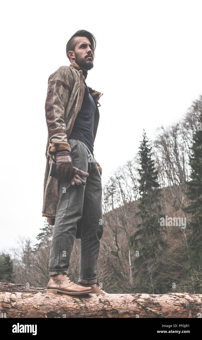 Les jeunes hommes sur des rondins dans la forêt. Cuir et jeans Banque D'Images