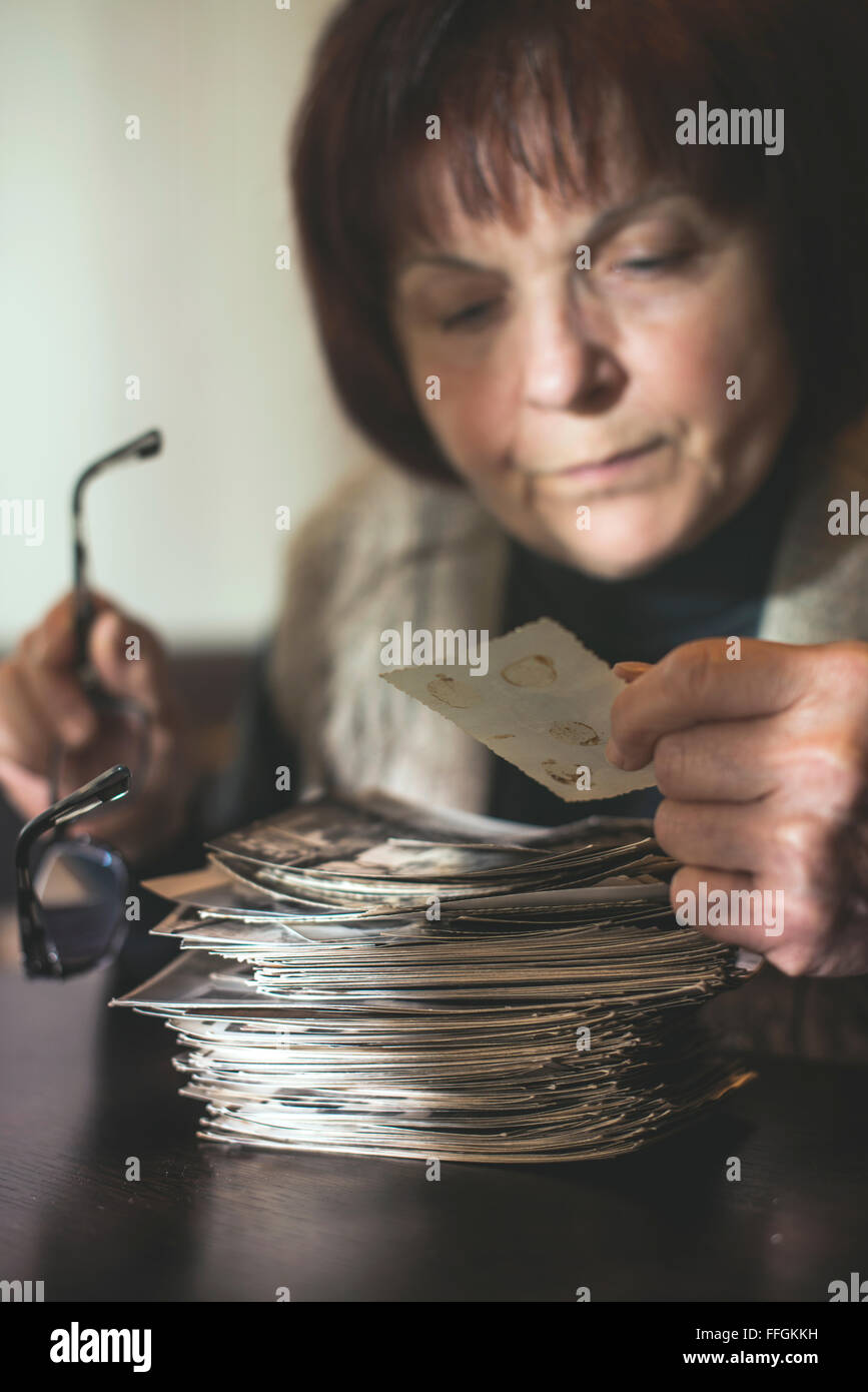 Senior woman regarder de vieilles photos. Tristesse Banque D'Images