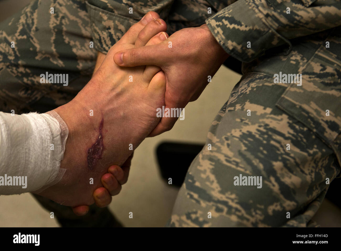 Le Lieutenant Justin agriculteur, un médecin assistant à la 66e clinique médicale, Hanscom Air Force Base, Mass., teste la souplesse de la reparation pied gauche du Capitaine Adam Davis lors d'un examen de suivi. Le Capitaine Davis a subi plusieurs interventions chirurgicales et d'un graphique de la peau pour réparer les jambes et les pieds après avoir été gravement blessé dans l'attentat du Marathon de Boston. Banque D'Images