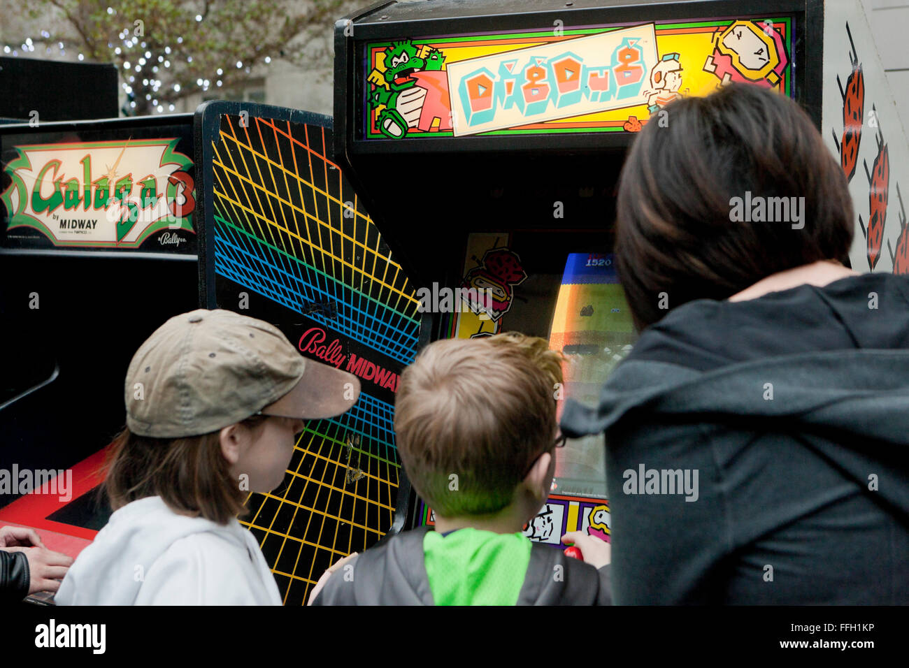 Enfants jouant Dig Dug arcade jeu vidéo - USA Banque D'Images