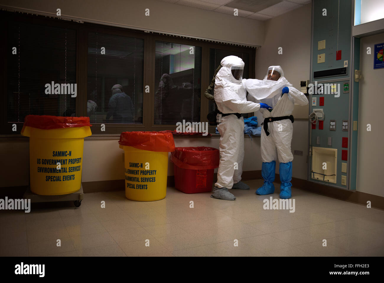 Capts de l'armée américaine. Kirt Cline et Troy Dilmar déposer leur équipement de protection individuelle lors de la formation au centre médical militaire de San Antonio, Texas. Cline et Dilmar font partie de la Défense du ministère de l'équipe de 30 membres, conçus pour répondre à une éventuelle épidémie de virus Ebola dans les États-Unis. Banque D'Images