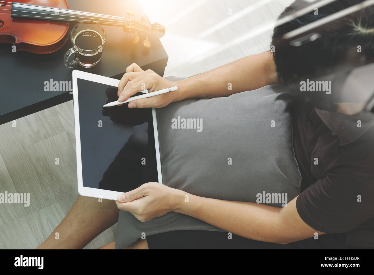 Hipster part composer la musique avec tablette numérique compter et sitting on sofa at home studio Banque D'Images